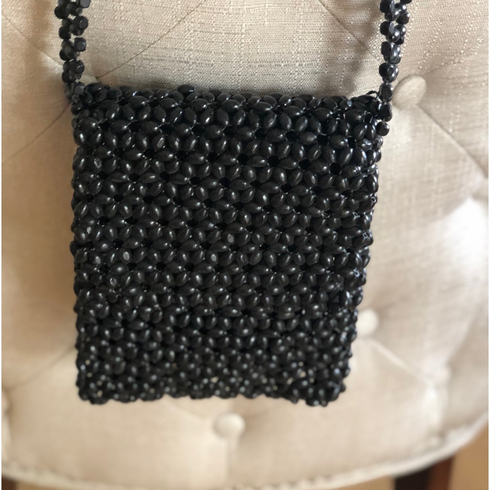 Wood beads beans like black small crossbody bag.  Very light.